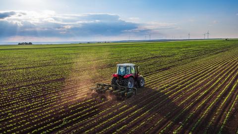 Tractor cultivating field at spring