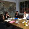 Women and a man sitting around a desk in an office