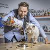 Rostyslav Vovk, co-owner of Kormotech in Lviv, feeds House, his West Highland White Terrier